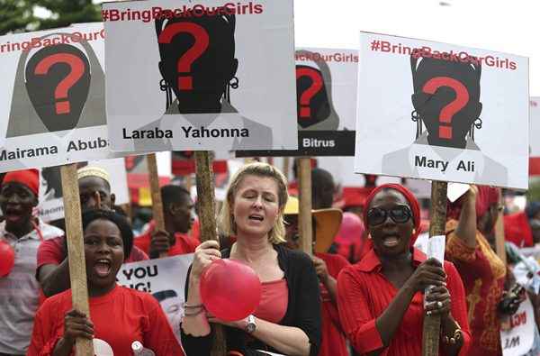 Mulheres carregam cartazes em um protesto exigindo a libertação de meninas da escola secundária raptadas na remota aldeia de Chibok