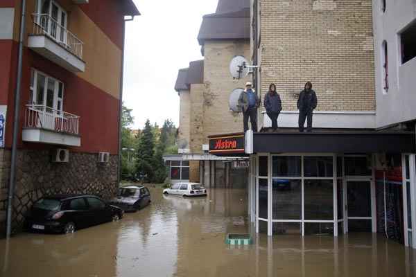 Pessoas ficam em cima de edifício, à espera de alimentos, em Maglaj, na Bósnia