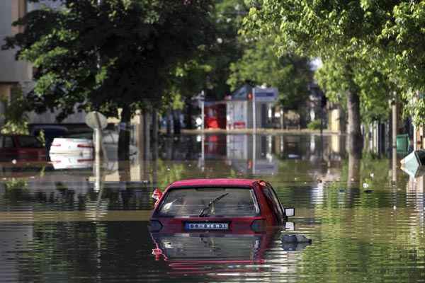 Carro fica quase submerso na cidade inundada de Obrenovac, a sudoeste de Belgrado, na Sérvia