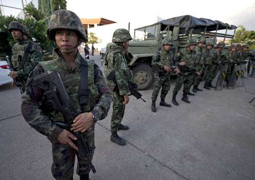 Soldados tailandeses ficam de guarda depois que o chefe do Exército, general Prayut Chan-O-Cha se reuniu com líderes anti-governo e pró-governo no Clube do Exército, em Banguecoque