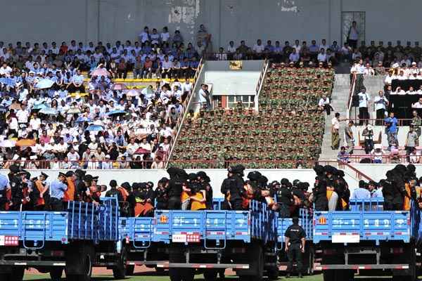 Caminhões transportam acusados de crimes em julgamento em estádio de Yili, na região autônoma de Xinjiang, na China