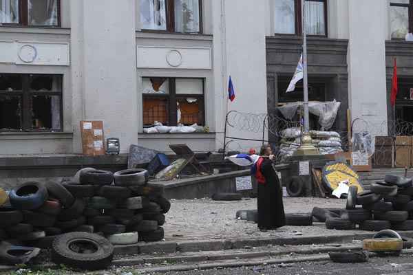 Homem segura bandeira russa em frente ao prédio da administração regional de Luhansk, no Leste da Ucrânia