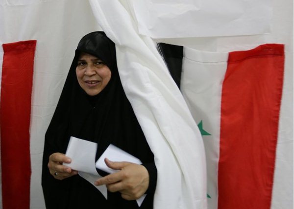 Uma mulher síria sai de uma cabine de votação depois de votar na eleição presidencial na terça-feira