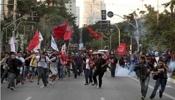 Pessoas fogem de gás lacrimogêneo disparados pela polícia durante o quinto dia de protesto dos trabalhadores de metrô em São Paulo