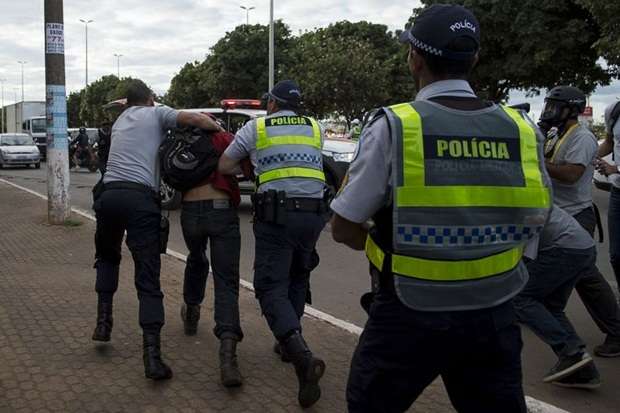 Homem é detido pela polícia durante protesto