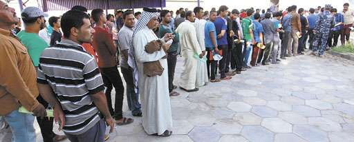 Moradores da cidade sagrada xiita de Najaf fazem fila para combater o avanço dos jihadistas no norte