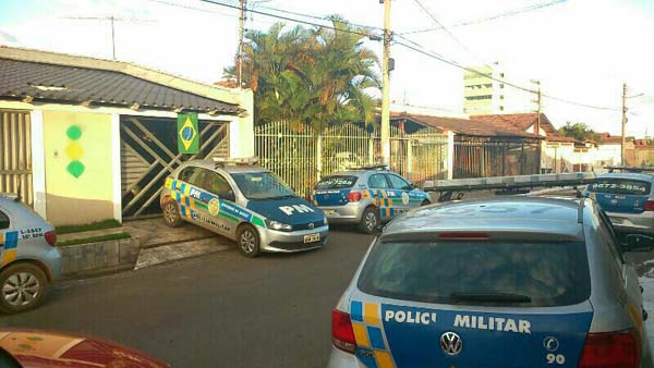 Os carros estavam estacionados próximo a uma casa decorada para a Copa