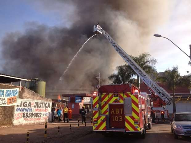 Os bombeiros tentam controlar o incêndio próximo à feira