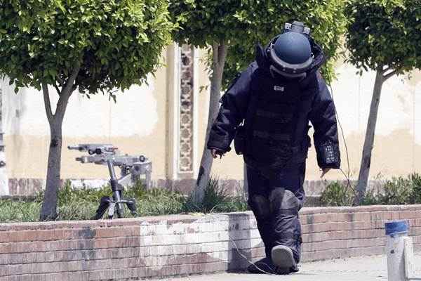 Investigador carrega detector bomba em frente ao palácio presidencial, no Cairo