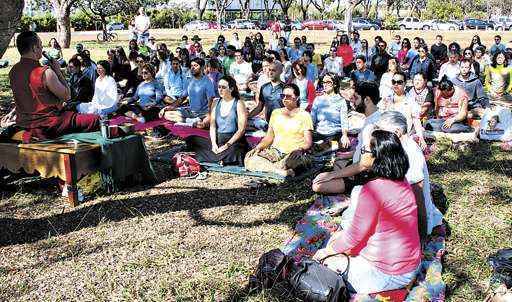 Praticantes e curiosos de todas as idades dedicaram parte do tempo à meditação no gramado do parque