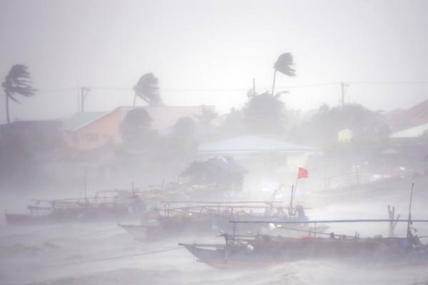 Barcos de pesca enfrentam fortes ventos e chuvas trazidas pelo tufão Rammasun, na cidade de Imus