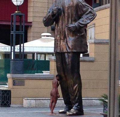 Uma foto postada no Twitter mostrou a mulher nua e com a cabeça inclinada contra o joelho da estátua