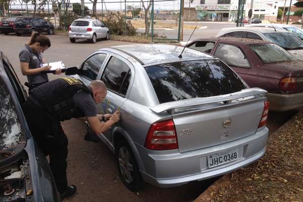 Policiais colhem vestígios do crime no carro atingido