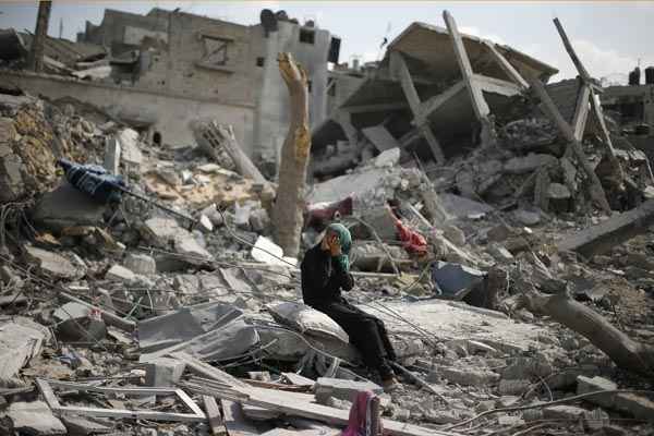 Palestina senta sobre os escombros de casa destruída após o retorno à cidade Beit Hanoun, no norte da Faixa de Gaza