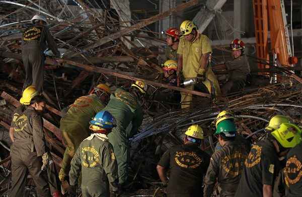 Equipes de resgate procuram sobreviventes entre os destroços de um prédio em colapso