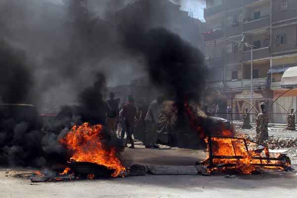 Manifestantes que apoiam a Irmandade Muçulmana participam de protesto próximo a pneus em chamas, em Matariya, no Cairo