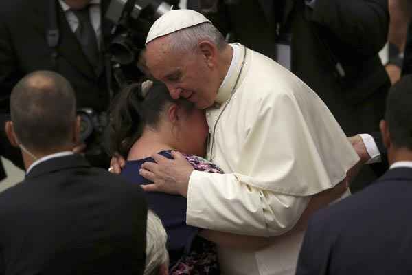 Papa abraça fiel durante audiência na sala Paulo VI. 