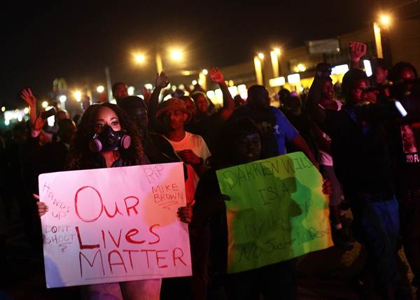 Manifestantes protestam contra a morte de Michael Brown, em Ferguson, na noite dessa terça-feira (19/8)