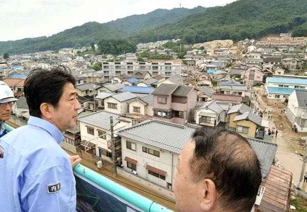 O primeiro-ministro Shinzo Abe inspeciona área residencial atingida por deslizamento de terra em Hiroshima