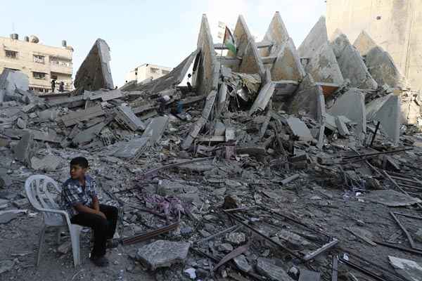 Palestino é visto próximo a edifício que teria sido derrubado em ataques aéreos israelenses na cidade de Gaza