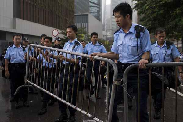 Sob chuva, policiais ajustam barreiras de aço em frente ao escritório do chefe do Executivo Leung Chun-ying, em Hong Kong: governo deixa claro que não irá recuar diante de distúrbios