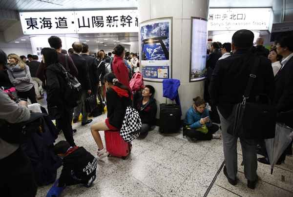 Os passageiros aguardam para a retomada dos serviços de trem-bala depois de terem sido suspensas devido à fortes ventos e chuva forte causadas pelo tufão Phanfone