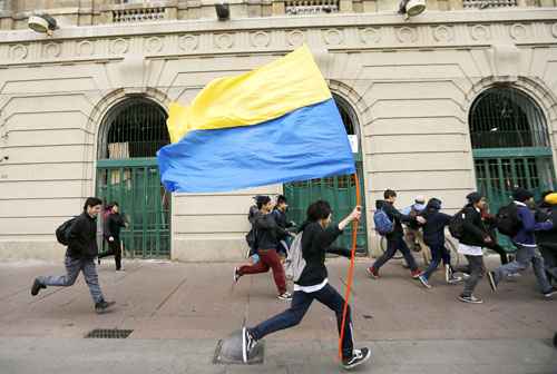 Estudantes correm da repressão policial durante manifestação, em agosto passado: alunos temem que reformas de Bachelet para a educação sejam insuficientes