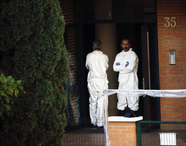 Profissionais com roupas de proteção do lado de fora da entrada do prédio da enfermeira que contraiu ebola, em Alcorcón, arredores de Madrid