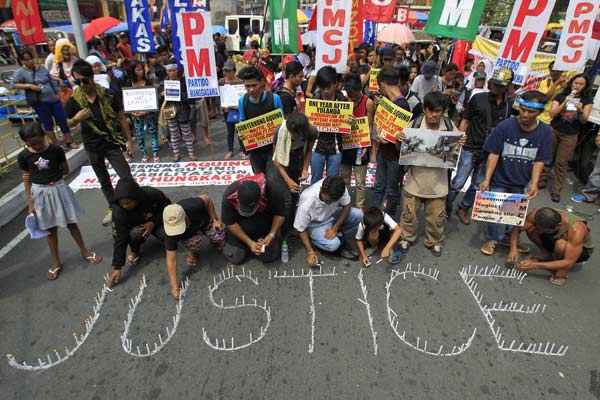 Manifestantes acendem velas e pedem justiça para as vítimas do tufão Haiyan durante um protesto em frente ao palácio presidencial em Manila