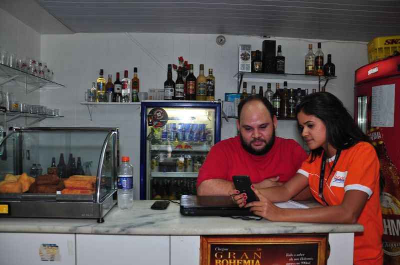 A voluntaria da Ambev, Mariana Louande, durante visita de concientização no bar de Francisco Carlos Albuquerque na Asa Norte