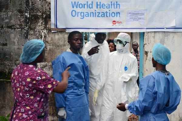 Profissionais de saúde na entrada da unidade de tratamento do ebola no Centro Médico John F. Kennedy, na capital da Libéria, Monróvia