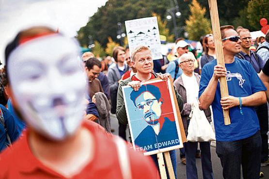 Ativistas defendem a proteção de dados digitais e exibem imagem de Snowden, durante protesto em Berlim: EUA no centro do escândalo