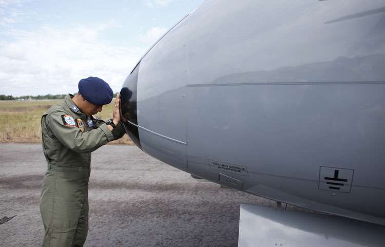 Membro da marinha Indonésia faz oração antes de missão para resgatar corpos de vítimas