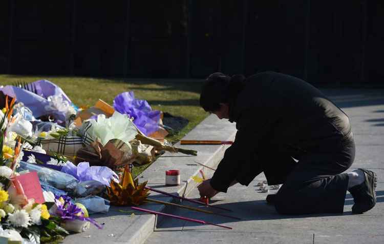 Homem deixa flores em homenagens às vítimas