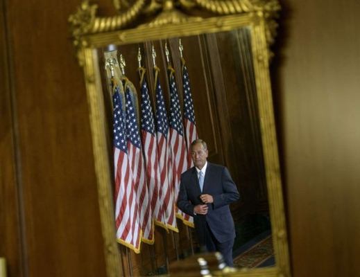 John Boehner é visto em um espelho enquanto caminhava entre congressistas durante a cerimônia de posse