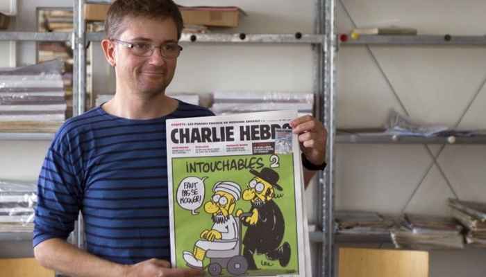 Charb, editor da revista Charlie Hebdo, mostra a edição de 2012 com várias caricaturas do profeta Maomé