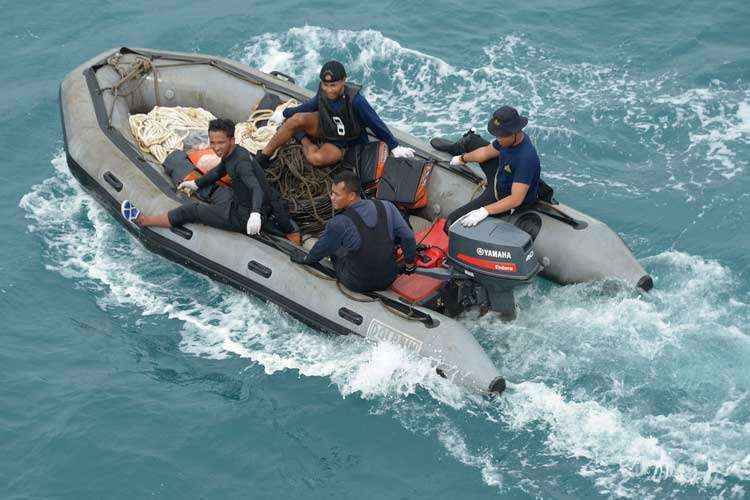 Mergulhadores da Marinha da Indonésia participam de busca para retirar a cauda do avião do mar