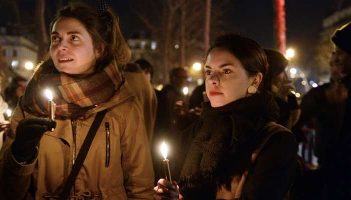 Na Praça da República, pessoa seguram velas e prestam homenagem aos 12 mortos no atentado