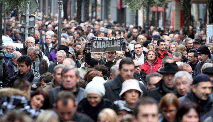 A multidão, reunida sob um frio sol de inverno, alterna slogans como 