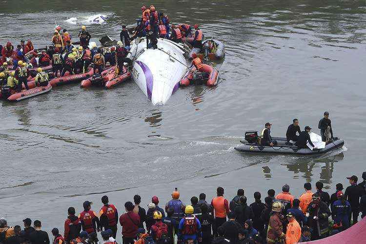 Equipes de resgate removem corpo de vítima após acidente de avião TransAsia Airways