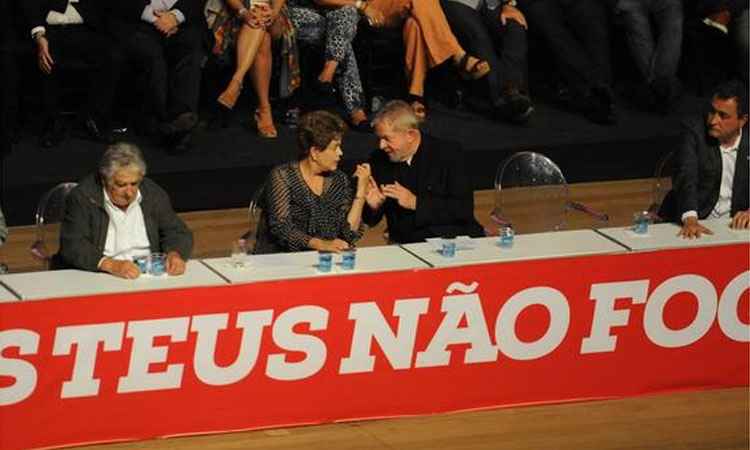 Na mesa, o governador Fernando Pimentel, os presidentes Pepe Mujica, do Uruguai, e Dilma Rousseff e o ex-presidente Lula: militância conclamada a 'andar de cabeça erguida'