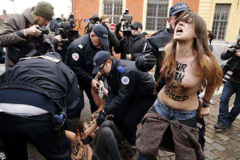 Policiais prendem ativistas de topless durante protesto na entrada do tribunal de Lille, na França