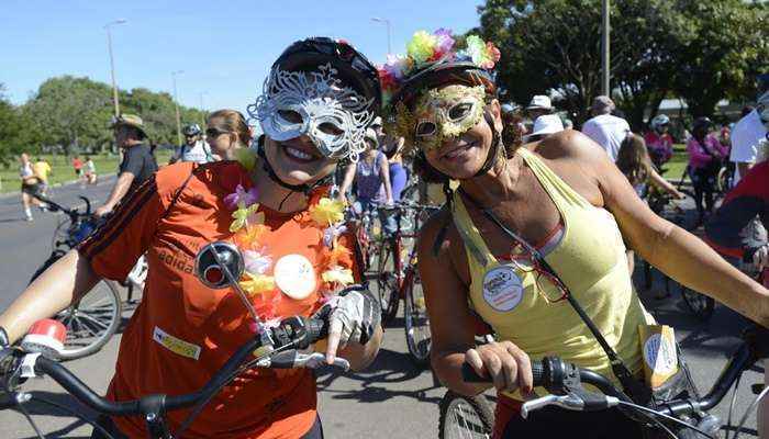 De máscara e bicicleta, foliões pulam carnaval no Eixão Norte