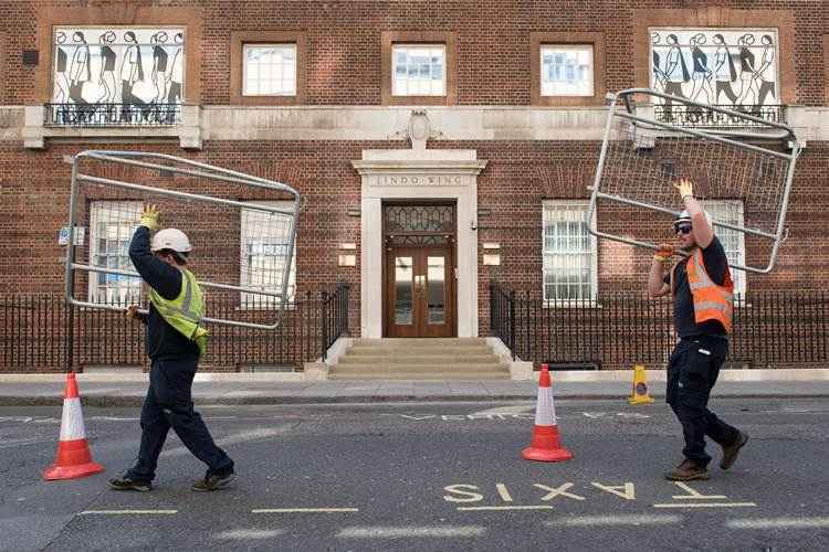 Trabalhadores erguem barreiras de segurança fora do hospital de St Mary ,em Londres , onde a duquesa de Cambridge vai dar à luz