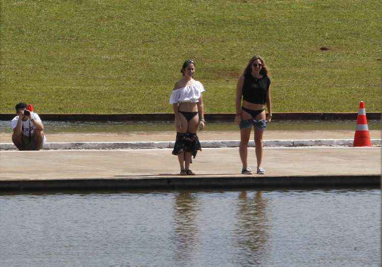 Duas jovens ficaram só de calcinha em frente ao espelho d'água do Congresso Nacional, na manhã desta sexta-feira (8/5). Atrás, um homem fotografa a dupla, que se mostra bem humorada