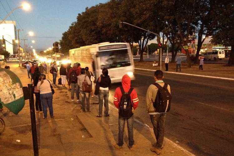 Pessoas aguardam algum tipo de transporte para chegar ao trabalho