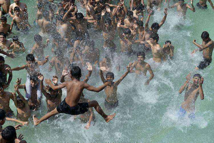 Jovens se refrescam na piscina