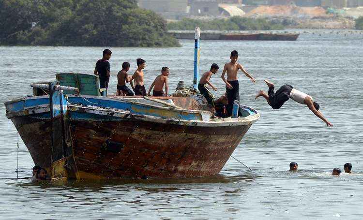 Jovens pulam na água para se refrescar: as temperaturas devem permanecer em 44,5 graus