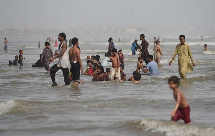 Paquistaneses se refrescam no mar durante onda de calor que atinge o país