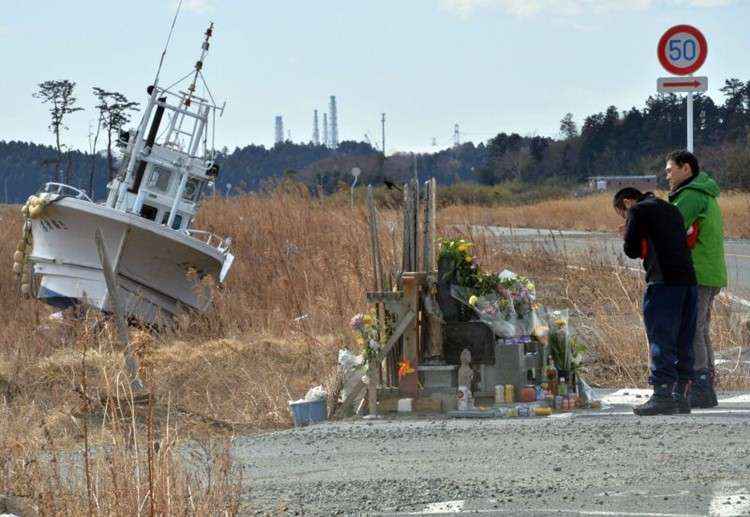 Homens fazem orações perto da central nuclear da tepco: milhares de moradores não sabem como reconstruir a vida após catástrofe